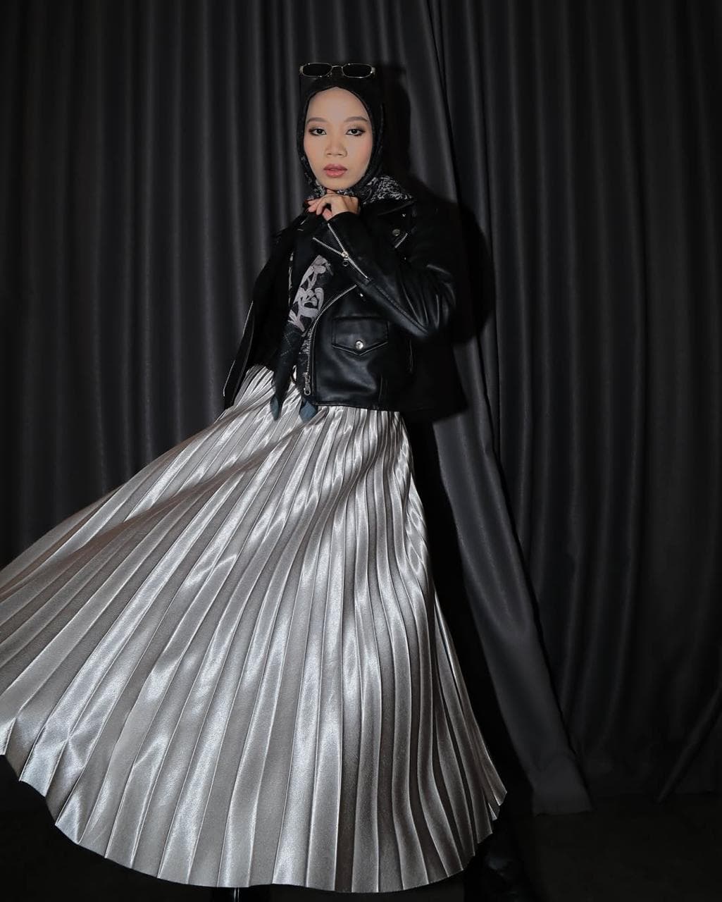 Model runway fashion TMA dengan jaket kulit dan rok silver pleated